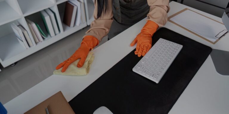 Custodian sanitizing common high-touch surfaces and desks